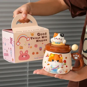 Kattmugg i keramik med lekfullt kattmotiv – vissa varianter med lock och sked