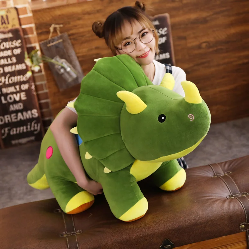 Dinosaurie gosedjur som stor, mjuk plyschkudde med kreativ design, 40–100 cm 24 Grön triceratros i plysch som hålls upp av en person.