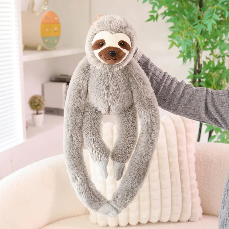 Sloth-gosedjur som mjuk plyschkudde och kramkudde med långa armar, 30–45 cm 23 Visa den grå sengångarplyschens långa armar när den står mot en ljus kudde.