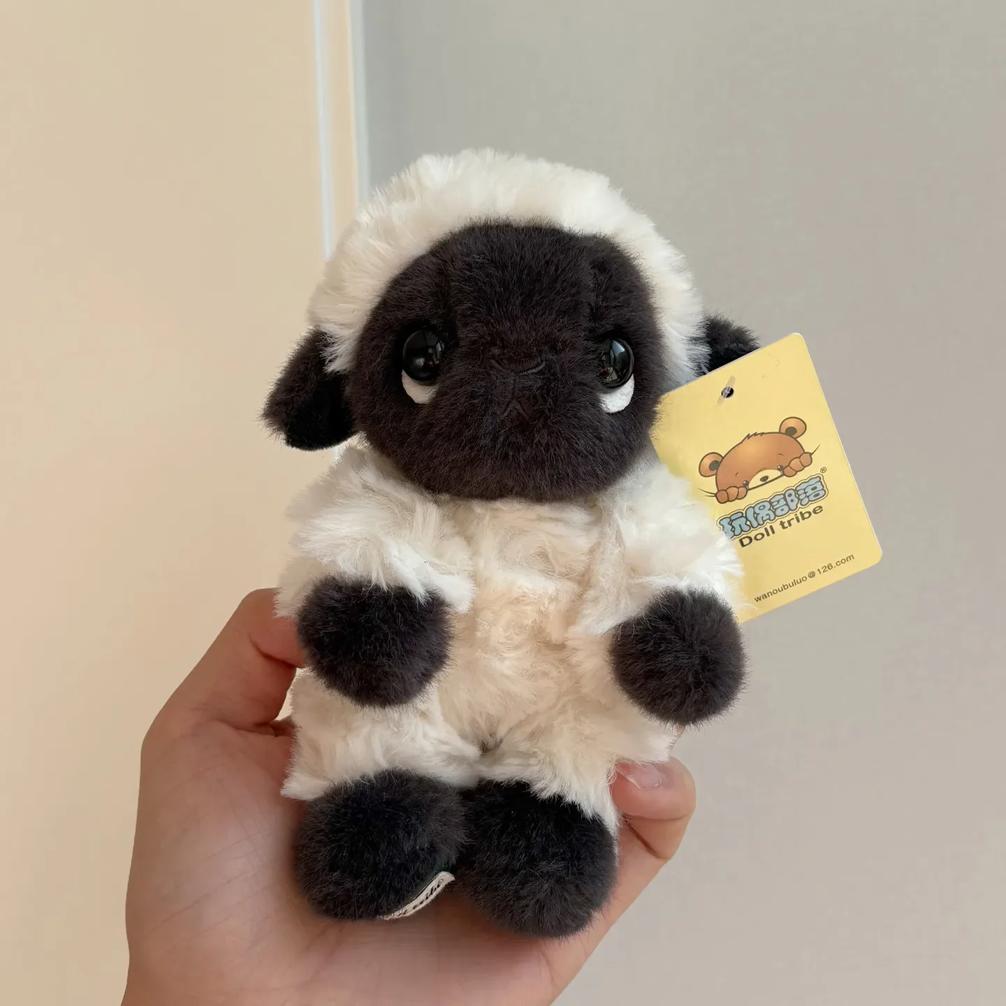 Kawaii-gosedjur av får och lamm med svart ansikte, nyckelringar för ryggsäck 19 Fåret visas framifrån i en hand, med svart ansikte och tassar samt en fäst etikett.
