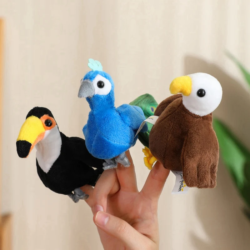 Små gosedjur som fingerpuppor i flera figurvarianter för lek och sagoberättande 44 En blå fågelpuppa visas mellan en svartgul och en brunvit fågelpuppa.