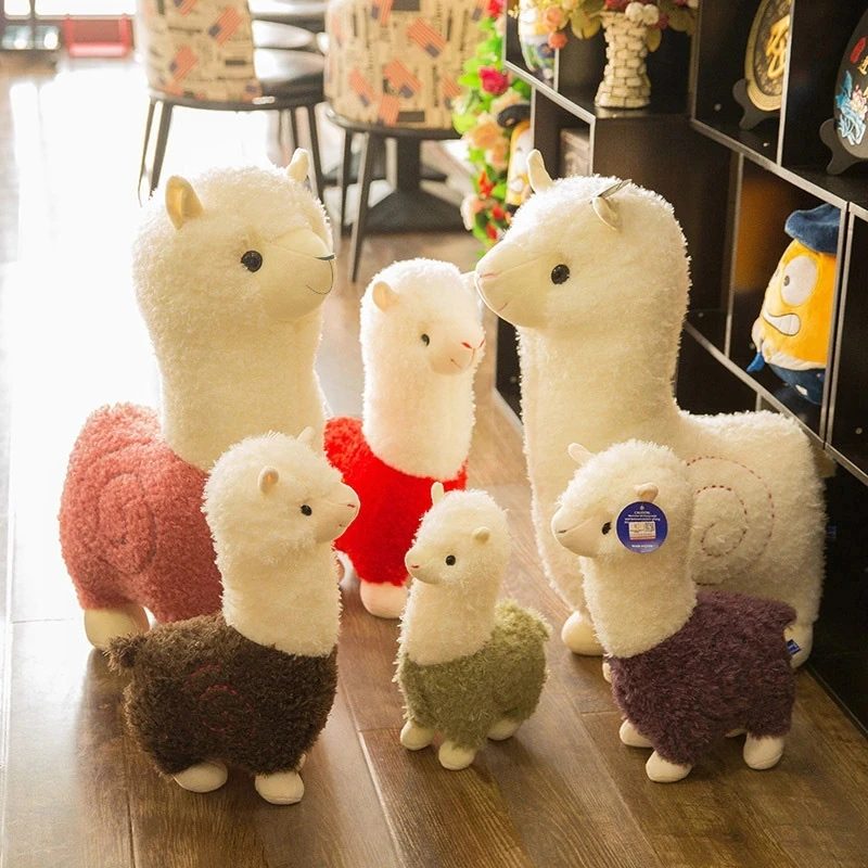 Får gosedjur, mjuk och red, alpaca alpackastil charmig liten, 25 cm 28 Flera alpackor i olika färger visas tillsammans i en inomhusmiljö.