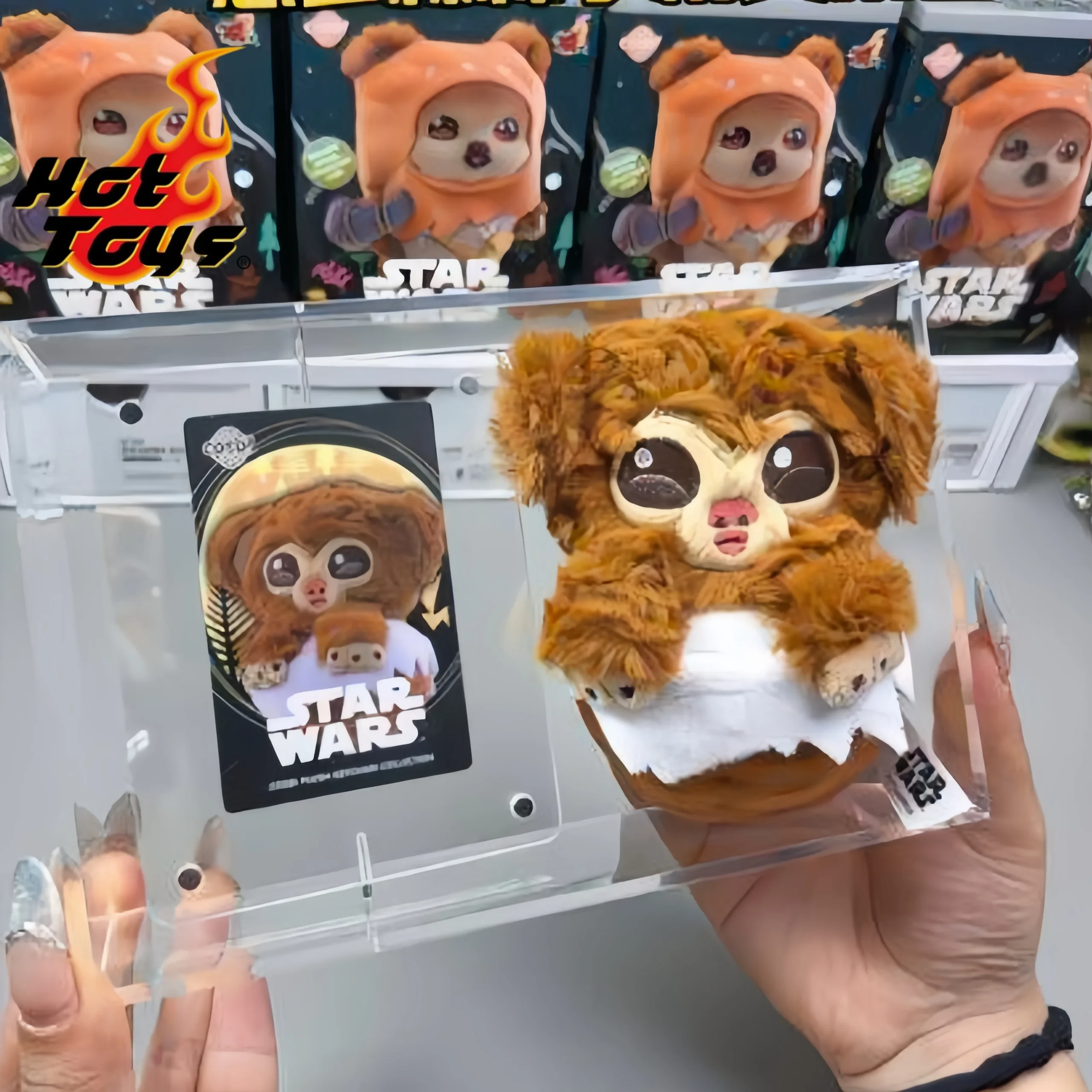 Star Wars Ewoks Cosbi-mjukisdocka, nyckelring och ryggsäckshänge i blindbox, serie 2 44 Visa den bruna, lurviga figuren i handen med förpackningen i bakgrunden.
