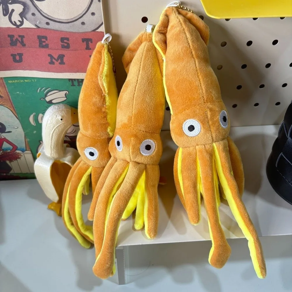 Bläckfisk som nyckelring, söt och Ocean series, squiddekoration tecknad style 20 Visa de orangefärgade bläckfiskhängen med gula detaljer på hyllan.