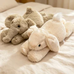 Kanin gosedjur i liggande form, med elefant, ko, lejon och gris som kramdjur och present