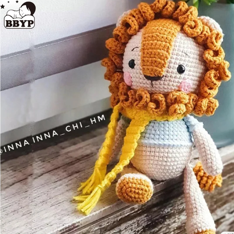 Lejon och elefant gosedjur, Amigurumi och kawaii, handgjord stickad stil handmade 68 Virkad lejonfigur med orange man, gul halsduk och ljusblå kropp i en inomhusmiljö.