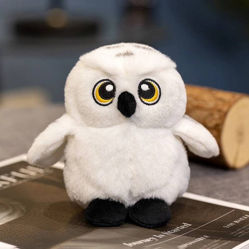 Uggla gosedjur med Hedwig i tecknad stil, mjuk och lekfull att bära på axeln 22 Uggleplyschen står framifrån med sina gula ögon och svarta detaljer.