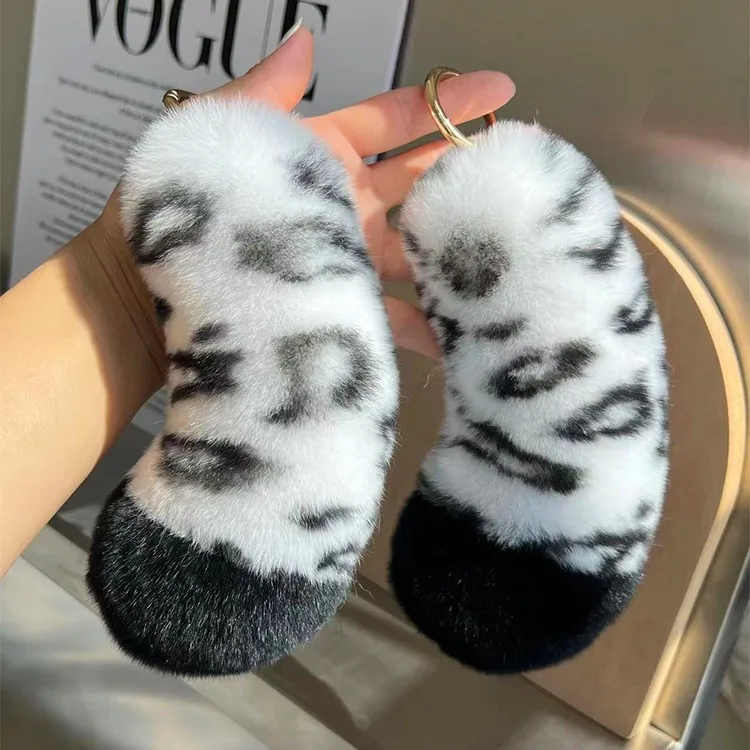 Kanin som nyckelring, Snow leopard print och söt, 12–15 cm 20 Två vita, svartfläckiga svansnyckelringar med fluffig yta och svarta spetsar.