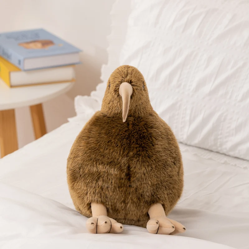 Brunt Kiwi bird gosedjur i verklighetstrogen stil, mjuk kudde som gåva, 12–28 cm 22 Ett brunt kiwi-gosedjur placerat på en säng.