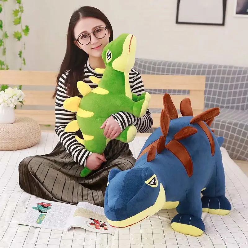 Dinosaurie gosedjur i tecknad stil, som mjukisdocka i grönt eller blått, 55–100 cm 22 Grönt och blått Stegosaurus-gosedjur med ryggplattor.