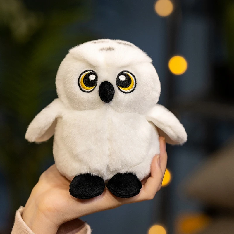 Uggla gosedjur med Hedwig i tecknad stil, mjuk och lekfull att bära på axeln 20 Vit uggleplysch med gula ögon visas hållen i en hand.