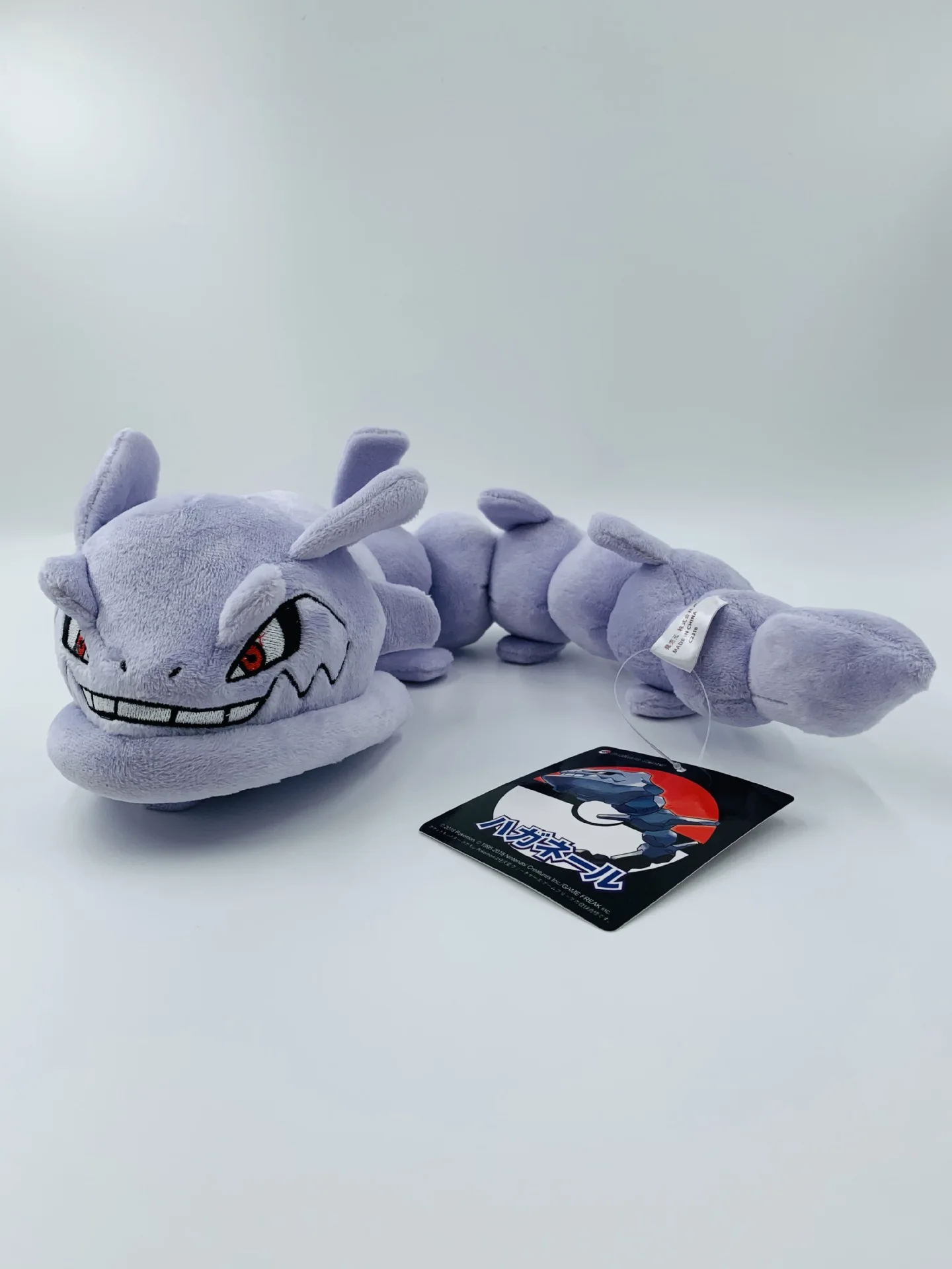Pokémon-karaktärer gosedjur med böjbar och poserbar form, flexibel design, 30 cm 16 Visa den långa, segmenterade lavendelgrå plyschormen med synligt ansikte och tagg.