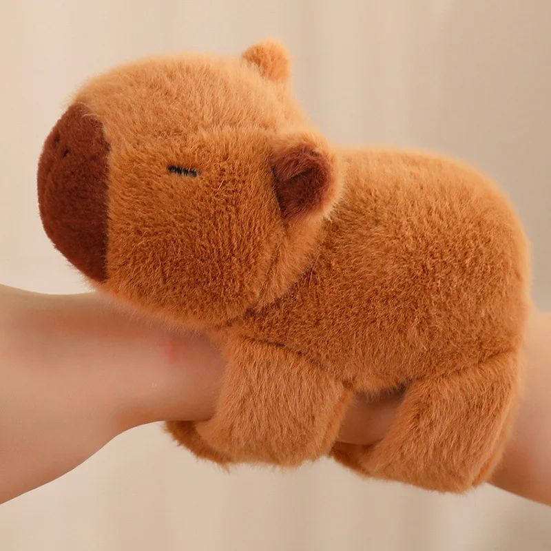 Kapybara gosedjur i kawaii-stil, utformat som ett smällarmband runt handleden 24 Visa den bruna mjukisfiguren formad som en kapybara från sidan.