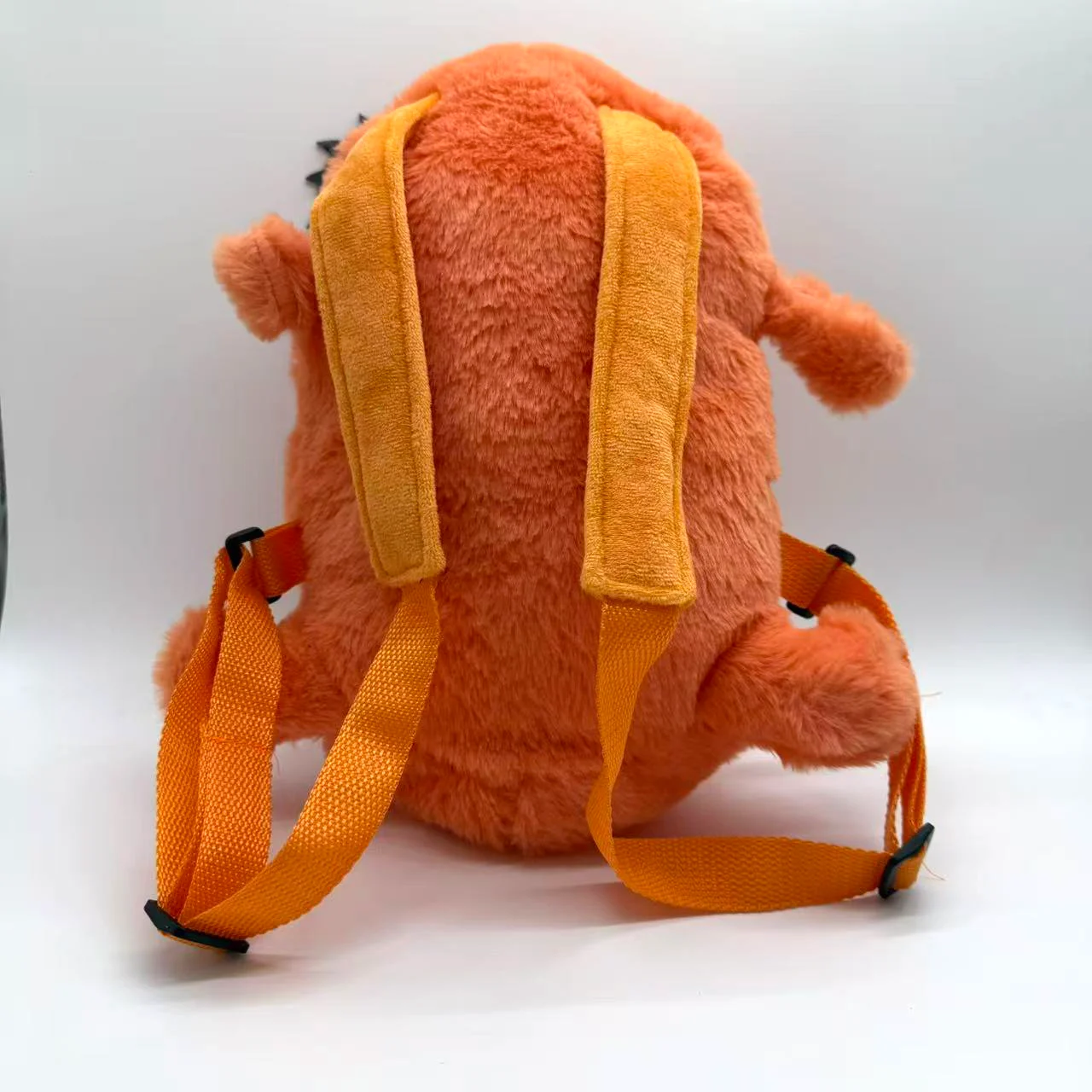 Ryggsäck med Pochita från Chainsaw Man i kawaii-stil, present för barn och vuxna 19 Bakvy av den orange karaktärsformade plyschryggsäcken med gula remmar.