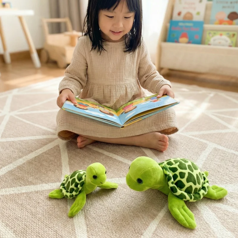 Grönt tortoise gosedjur med söt, naturtrogen design i vatteninspirerad stil 22 Barn läser bredvid två gröna plyschsköldpaddor i olika storlekar.