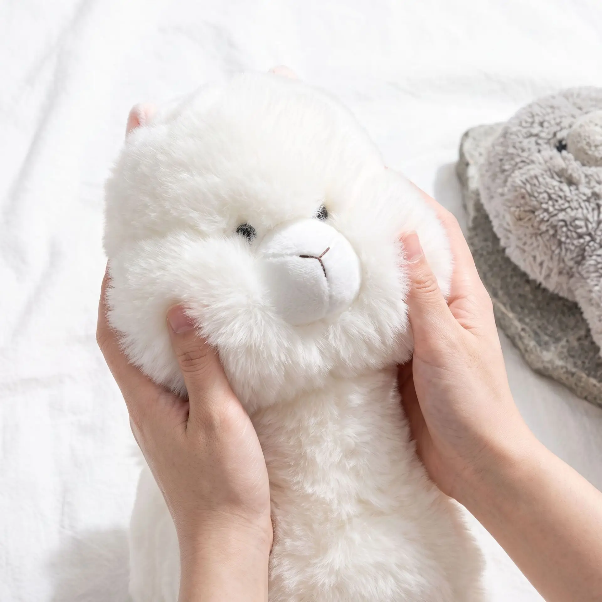 Alpaca gosedjur som plyschkudde, söt och kawaii style, lyckobringande stil, 22–45 cm 20 Närbild av en vit, fluffig alpacka som hålls i händerna.