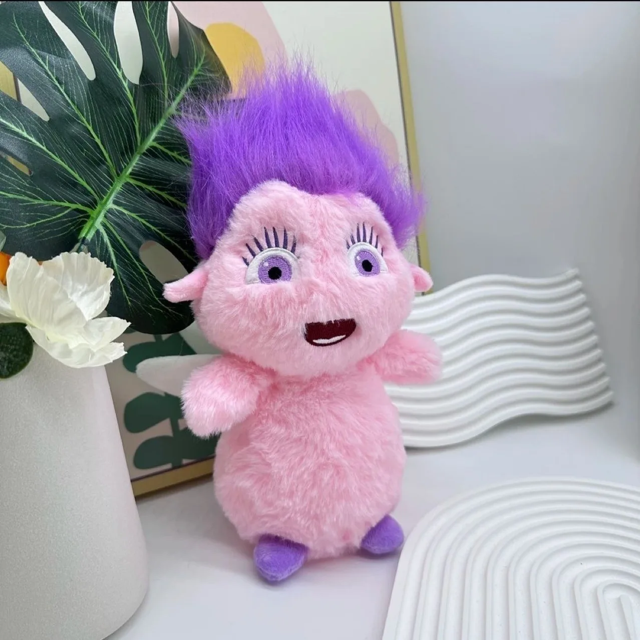 Bibble gosedjur som en mjuk och söt karaktärsdocka i animeinspirerad stil på, 25 cm 20 Rosa lurvig figur med hög lila frisyr, fotograferad i en inredd miljö.