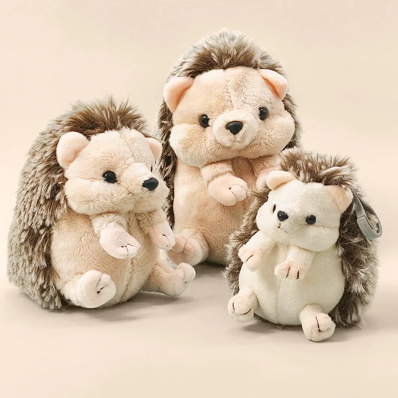 Sött hedgehog gosedjur, igelkott som plyschkudde och sovande kompis, 11–22 cm 20 Tre sittande igelkottsgosedjur i ljusa toner med mörkbruna taggar.