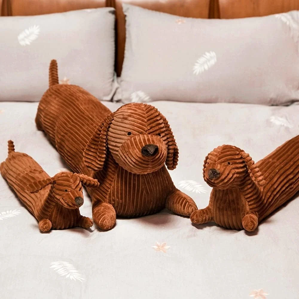 Dachshund som hundgosedjur, lång kroppskudde med söt och rolig stil, 50–110 cm 19 Visa de bruna, räfflade taxplyschdjuren i olika storlekar på sängen.