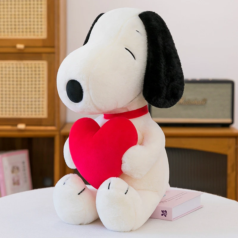 Snoopy som hundgosedjur, stor hjärtformad hundkudde i tecknad stil, 45–100 cm 23 Vit plyschhund med svart öra håller ett rött hjärta.