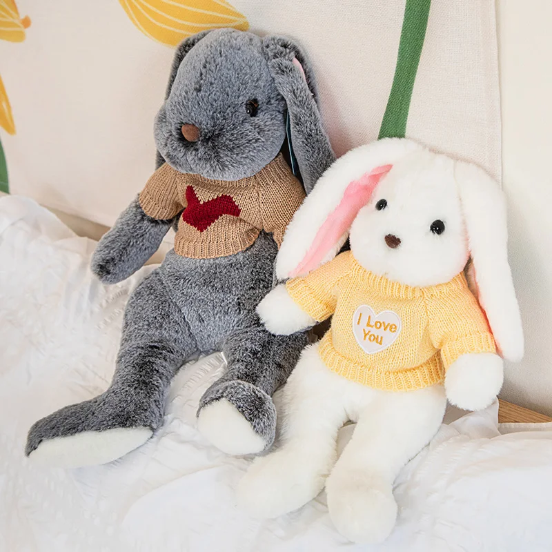 Kawaii kanin gosedjur med långa öron, sovande tecknad kramkudde som födelsedagspresent 50 En grå och en vit kanin i en säng.