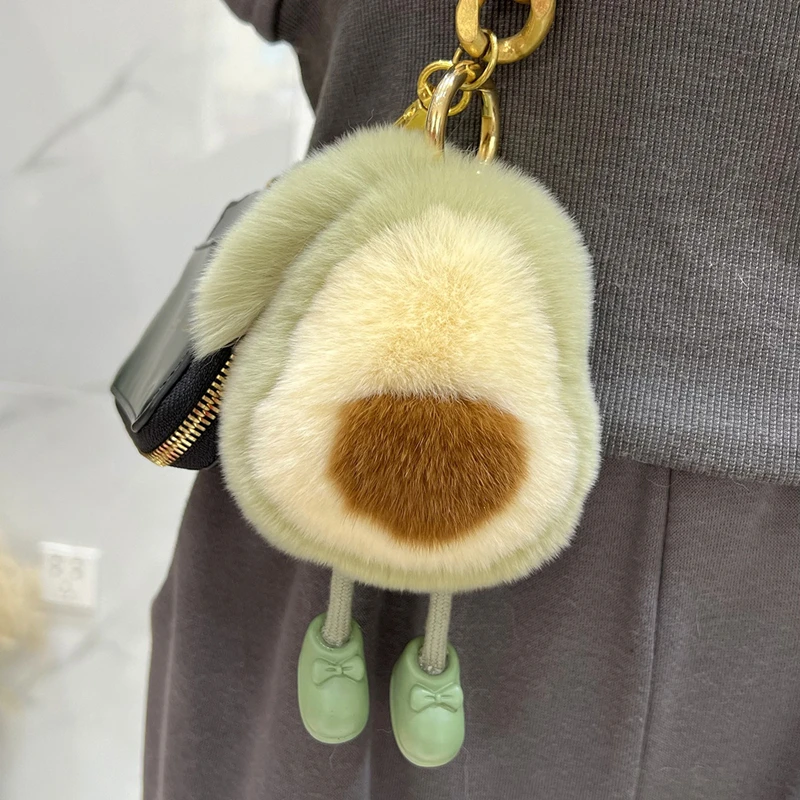 Avokadomotiv på söt kanindocka i kawaii-stil, som bilnyckelring och ryggsäckshänge 21 Avokadoformat mjukt hänge fäst vid en mörk väska.