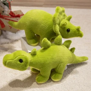 Grönt dinosaurie gosedjur i triangelform med tyrannosaurus rex, drakmotiv och vråldesign