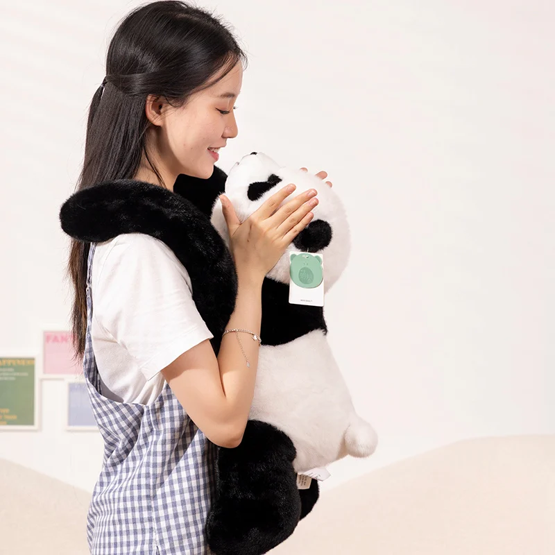 Söta björn gosedjur med långa armar, panda, dinosaurie och koala att bära på ryggen 32 Person som håller ett panda-gosedjur nära kroppen.