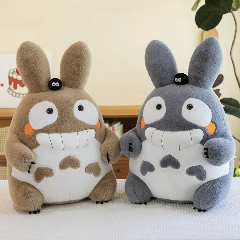 Totoro-kudde med stort leende, söt tecknad karaktärsdesign och mjuk lång form 23 Ett tanfärgat och ett grått långörat gosedjur står bredvid varandra i ett rum.