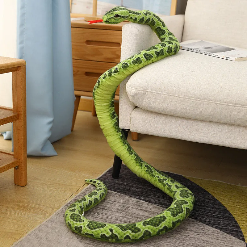 Python gosedjur, lång och jättestor med realistisk design i gyllene ton, 200 cm 20 Visa den gröna pytonormen draperad över en soffarm och slingrande över golvet.