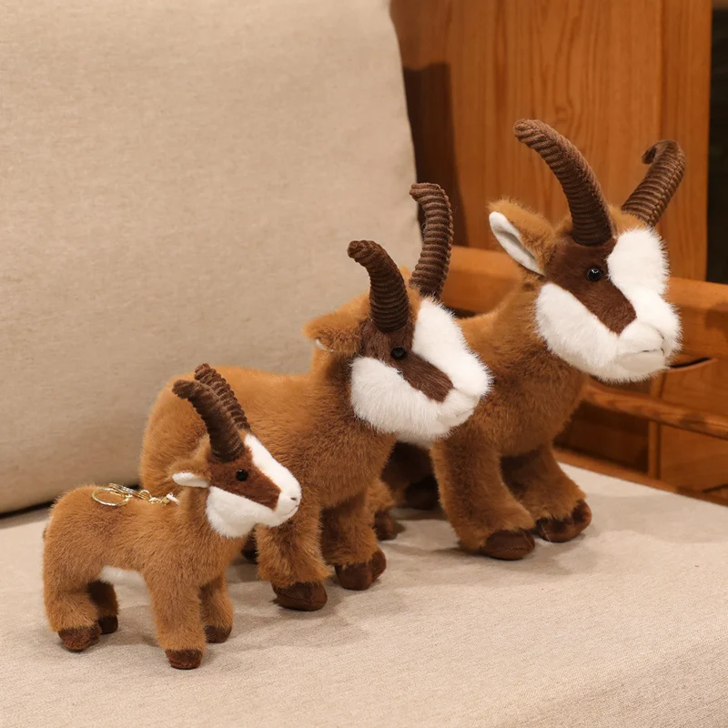 Realistiskt Ibex (wild goat) gosedjur med böjda horn, fluffigt ansikte och stående form 24 Tre kramdjur i olika storlekar.