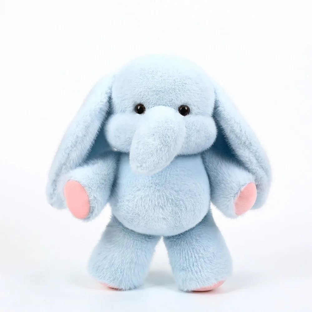 Elefant och tvättbjörn gosedjur som mjuk och fluffig plyschkudde för kramar 26 Visa den ljusblå elefantplyschen med rosa detaljer mot ljus bakgrund.