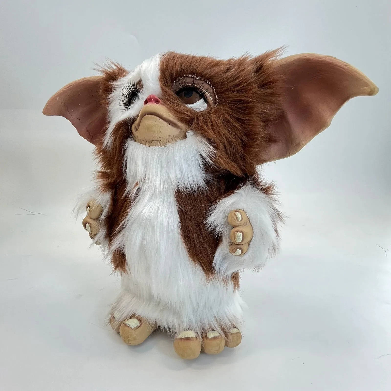 Flera figurvarianter av gosedjur i en söt, ovanlig och kawaii-inspirerad stil 21 Framifrån syns den brunvita monsterplyschens stora öron och ansikte.