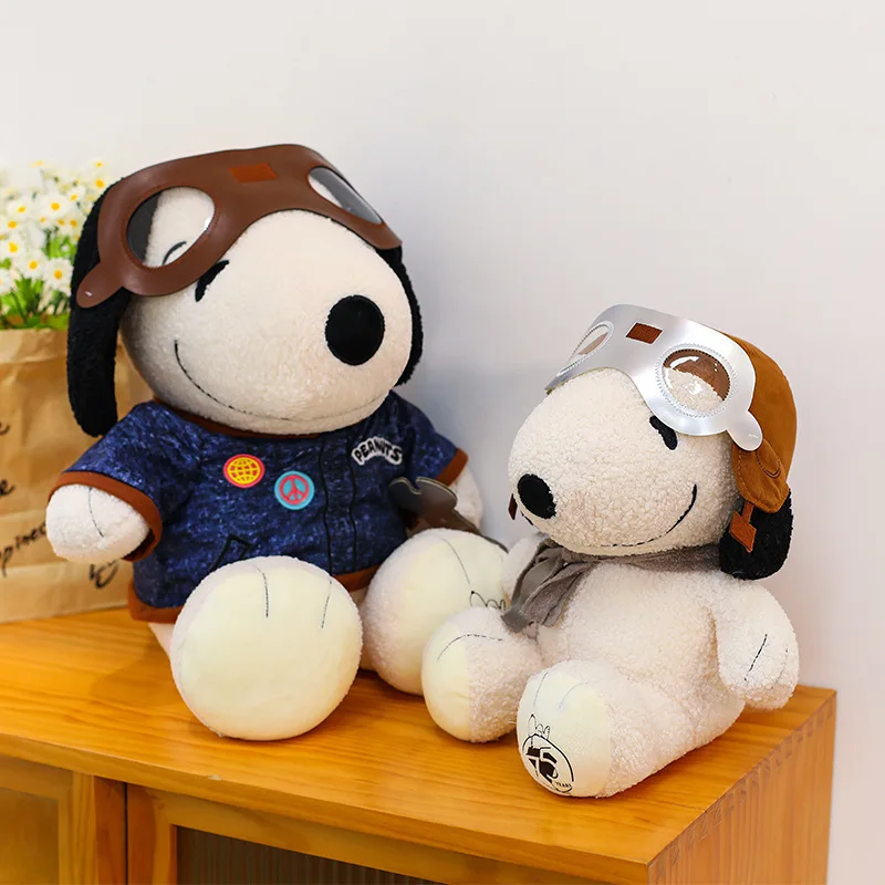 Snoopy panda gosedjur och plyschkudde med pilot- eller reparatörsmotiv i kawaii-stil 20 Två hundformade plyschfigurer i olika kläder och flygar-glasögon på ett träbord.