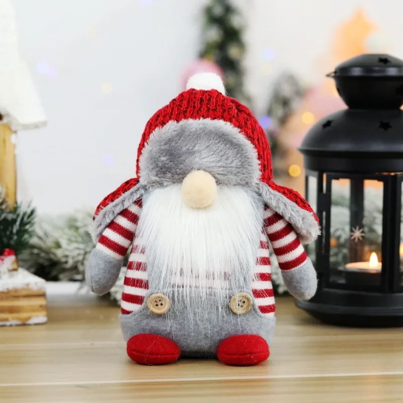 Ansiktslösa julgranshängen i dockform med God jul-text och flera figurvarianter 23 Röd julgnom med vit luva, långt skägg och randiga ärmar i julmiljö.