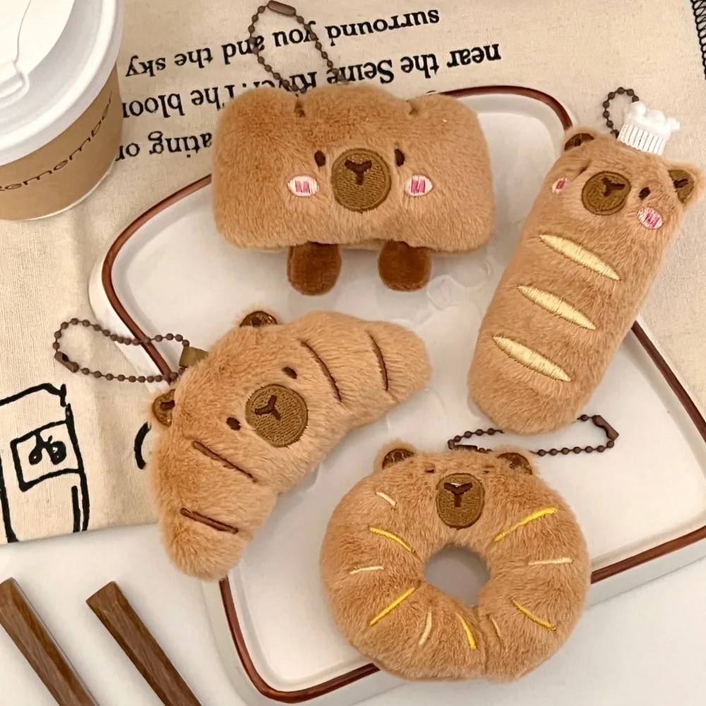 Kapybara- och delfinhängen i tecknad stil med bröd- och matmotiv samt kreativ design 34 Visa flera bruna brödformade capybara-hängen med ansikten och kedjor.