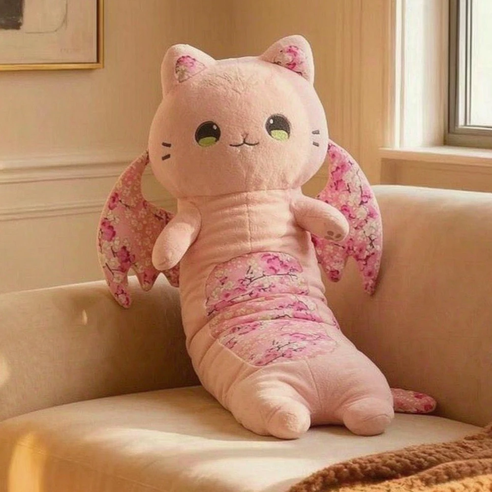 Rosa lucky cat som katt gosedjur och kramkudde med fladdermusvingar och sakurablommor 28 Plyschfigur av en katt placerad i en soffa som dekorativ detalj.