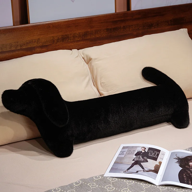 Hund gosedjur som hundkudde, Long och Leg support, 50–110 cm 32 Svart, långsträckt hundformad plysch ligger på en bädd.