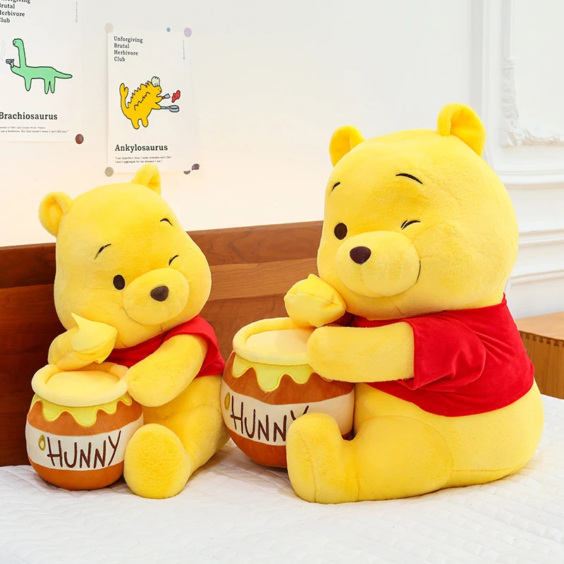 Winnie the Pooh gosedjur som stor och söt björnkudde i tecknad stil, 32–90 cm 22 Två gula björnplyschleksaker i olika storlekar med röda tröjor och honungsburkar.