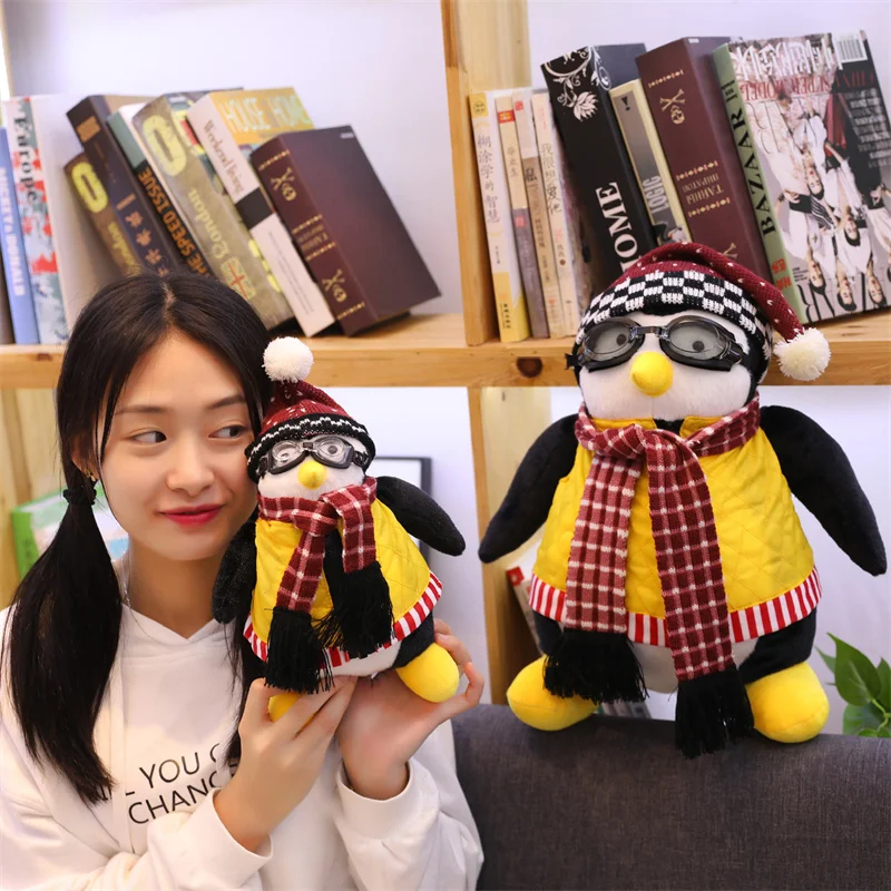Friends Hugsy pingvin gosedjur för fans, Joeys vän med avtagbara kläder, 27–47 cm 25 Två pingvinfigurer i vinterkläder i en visuell present- och samlarkontext.