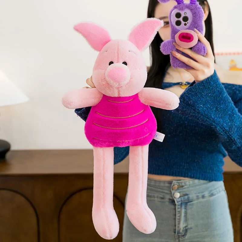 Piglet gosedjur som rosa plyschkudde med långa ben, söt tecknad stil, 55 cm 21 Visa grisgosedjuret i helfigur framför en person.