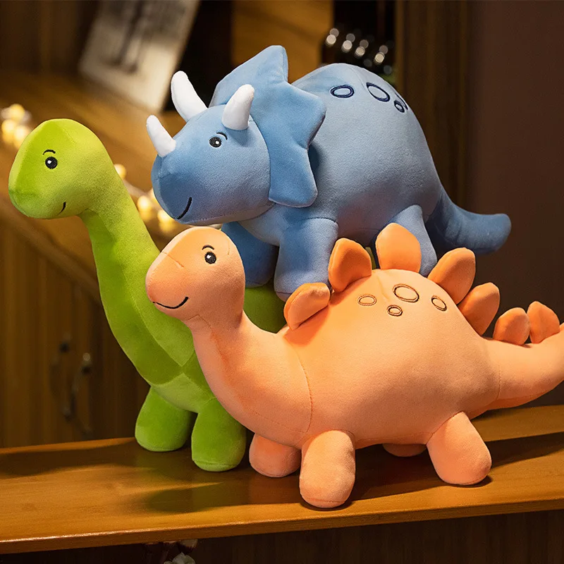 Färgglatt dinosaurie gosedjur med triceratopsmotiv i tecknad kawaii-stil för barn 34 Tre färgglada dinosaurieplushar staplade på varandra.