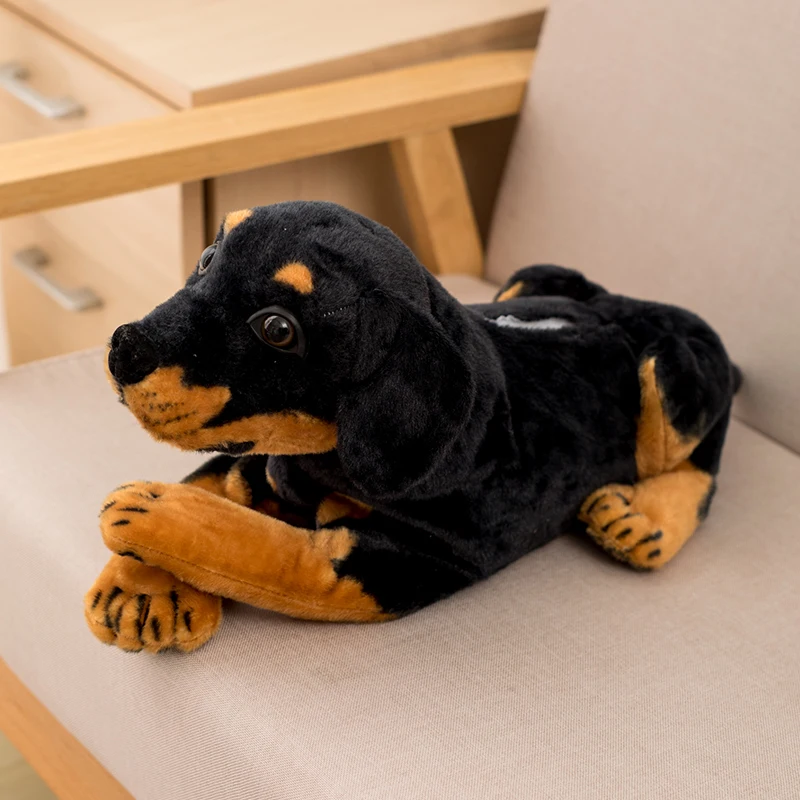 Hund gosedjur med naturtroget valpmotiv och förvaring för näsduksbox, 46 cm 26 Svart mjukishund med bruna markeringar visad liggande inomhus.