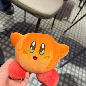 Samlarfigur i form av en orange Kirby-docka med arg min och tecknad spelstil 47 Samlarfigur i form av en orange Kirby-docka med arg min och tecknad spelstil