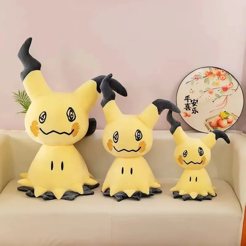 Mimikyu gosedjur från Pokémon med söt design, kroppskudde och soffkudde, 50–90 cm 20 Tre gula figurer i olika storlekar står uppradade på en soffa.