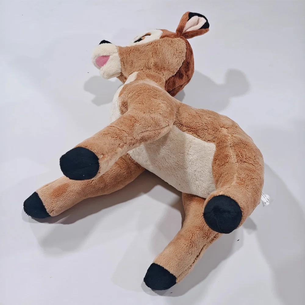 Mjukt och sött hjort gosedjur föreställande Bambi med dockliknande filmstil 18 Visa den bruna gosedjursdeerens kropp, ljusa mage och mörka hovar från en vinklad undersida.