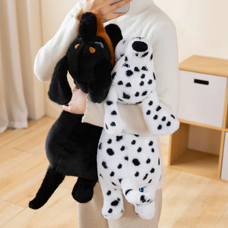 Hund gosedjur, svart and tan och vit, 60–100 cm 22 Visa de två hundarna, en svart med bruna detaljer och en vit med svarta fläckar.