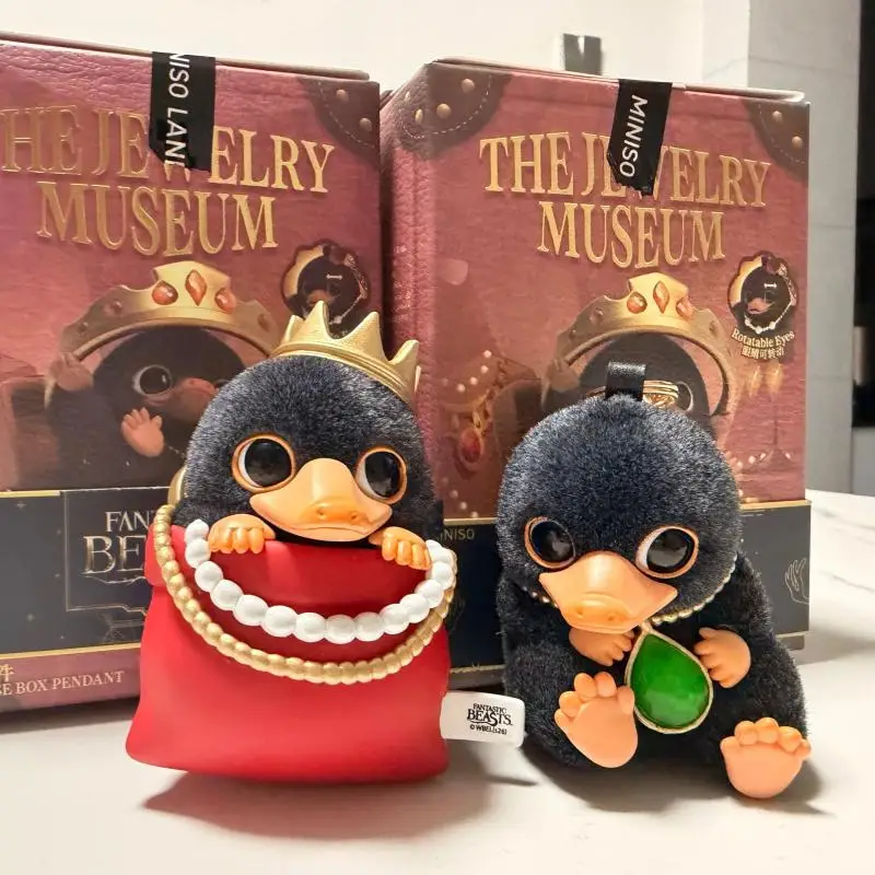 Niffler som flockad minifigur i Kawaii-stil, nyckelring från Smyckesmuseets serie 43 Visa de två svarta figurerna med näbbar och deras olika smycken och tillbehör.