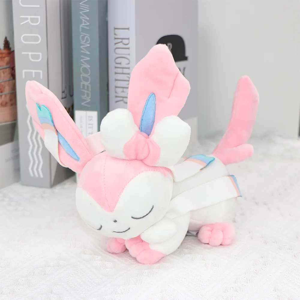 Pokémon-karaktärer gosedjur med sovande stil och flera figurer, långa, 18–27 cm 28 Rosa och vit mjuk figur med långa öron och blå detaljer, fotograferad liggande.