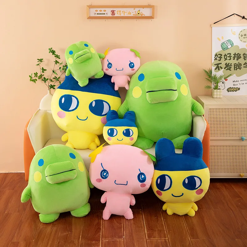 Tamagotchi-karaktärer gosedjur som plyschkudde i söt animeinspirerad stil, 40–90 cm 25 Flera gröna, rosa och gulblå karaktärsgosedjur visas tillsammans i olika storlekar.